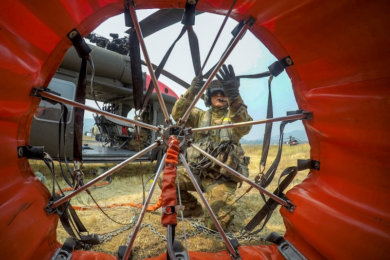 A soldier checks a massive bucket.