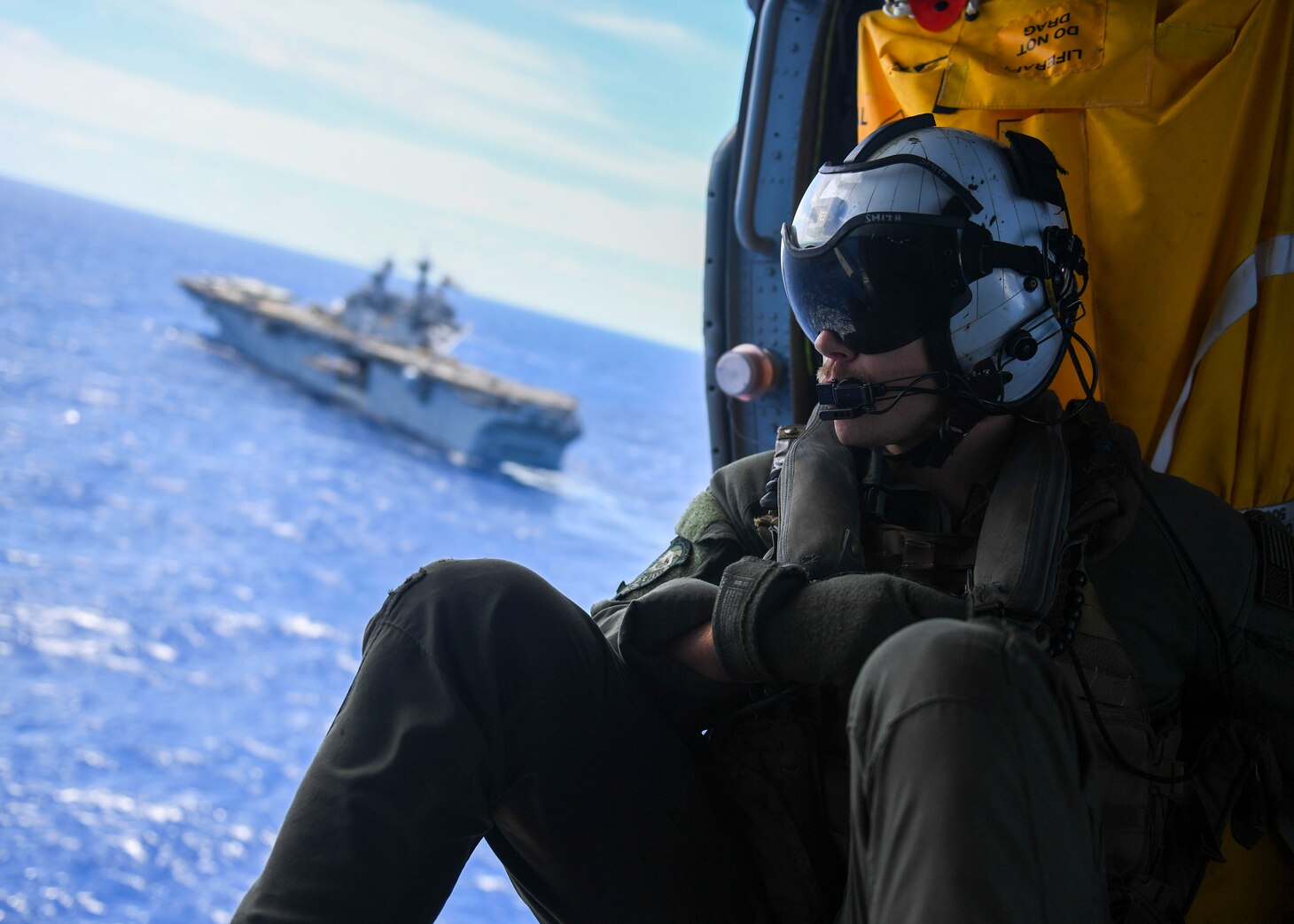 PACIFIC OCEAN (July 21, 2018) – Naval Aircrewman (Helicopter) 2nd Class Erick Smith, assigned to the “Blackjacks” of Helicopter Sea Combat Squadron (HSC) 21, rides in an MH-60S Sea Hawk helicopter during a vertical replenishment with Wasp-class amphibious assault ship USS Essex (LHD 2) during a regularly scheduled deployment of Essex Amphibious Ready Group (ARG) and 13th Marine Expeditionary Unit (MEU). The Essex ARG/MEU team is a strong, flexible, responsive, and consistent force capable of maneuver warfare across all domains; it is equipped and scalable to respond to any crisis from humanitarian assistance and disaster relief to contingency operations.