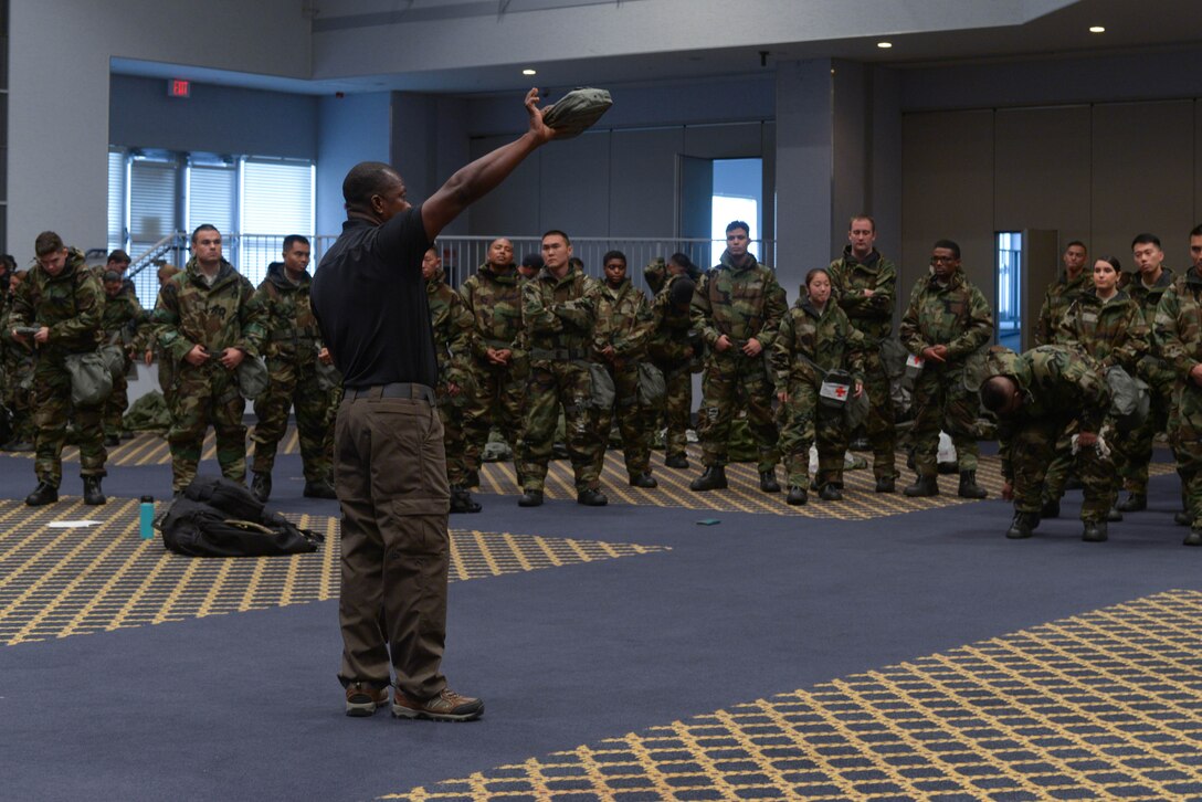 Mr. Laukton Rimpel, MCBC Instructor, demonstrates the usefulness of the personal first aid kit included with MOPP gear at Yokota Air Base, Japan, August 8, 2018