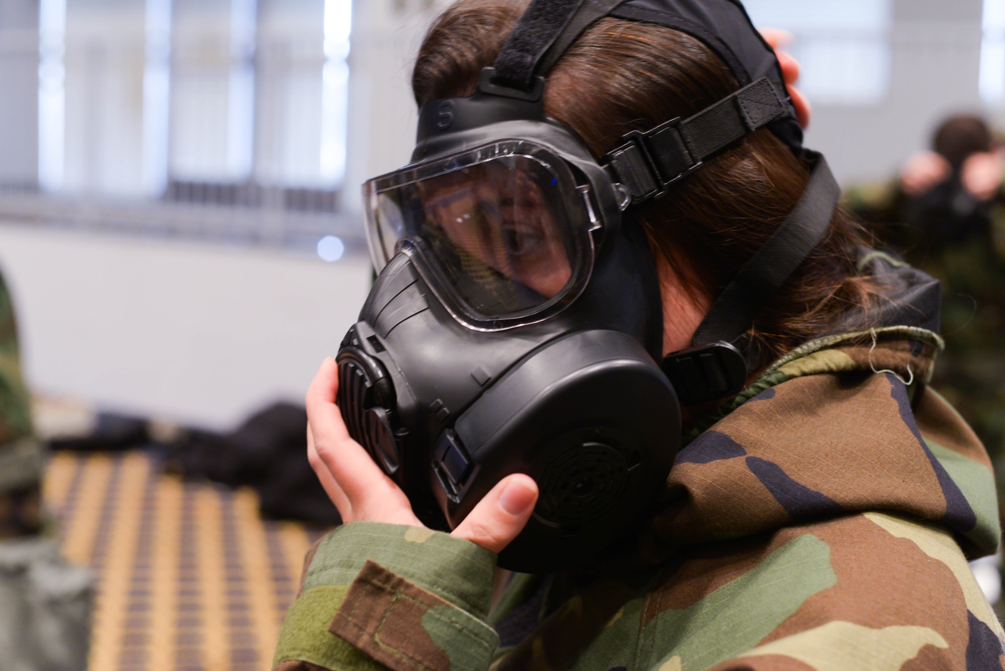 Mr. Laukton Rimpel, MCBC Instructor, demonstrates the usefulness of the personal first aid kit included with MOPP gear at Yokota Air Base, Japan, August 8, 2018