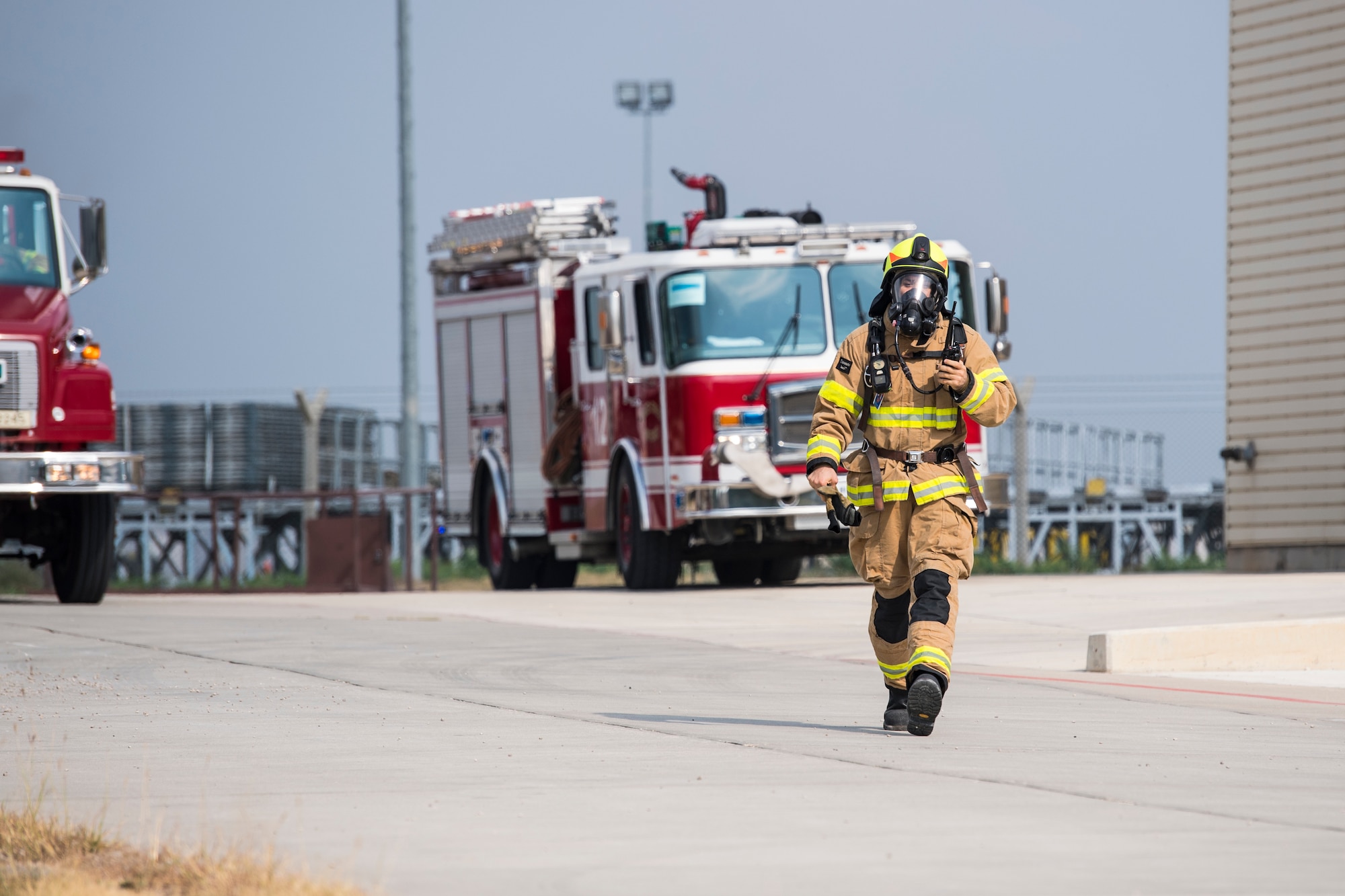 A firefighter walks to scene of simulated aircraft fire at Incirlik Air Base, Turkey, Aug. 7, 2018