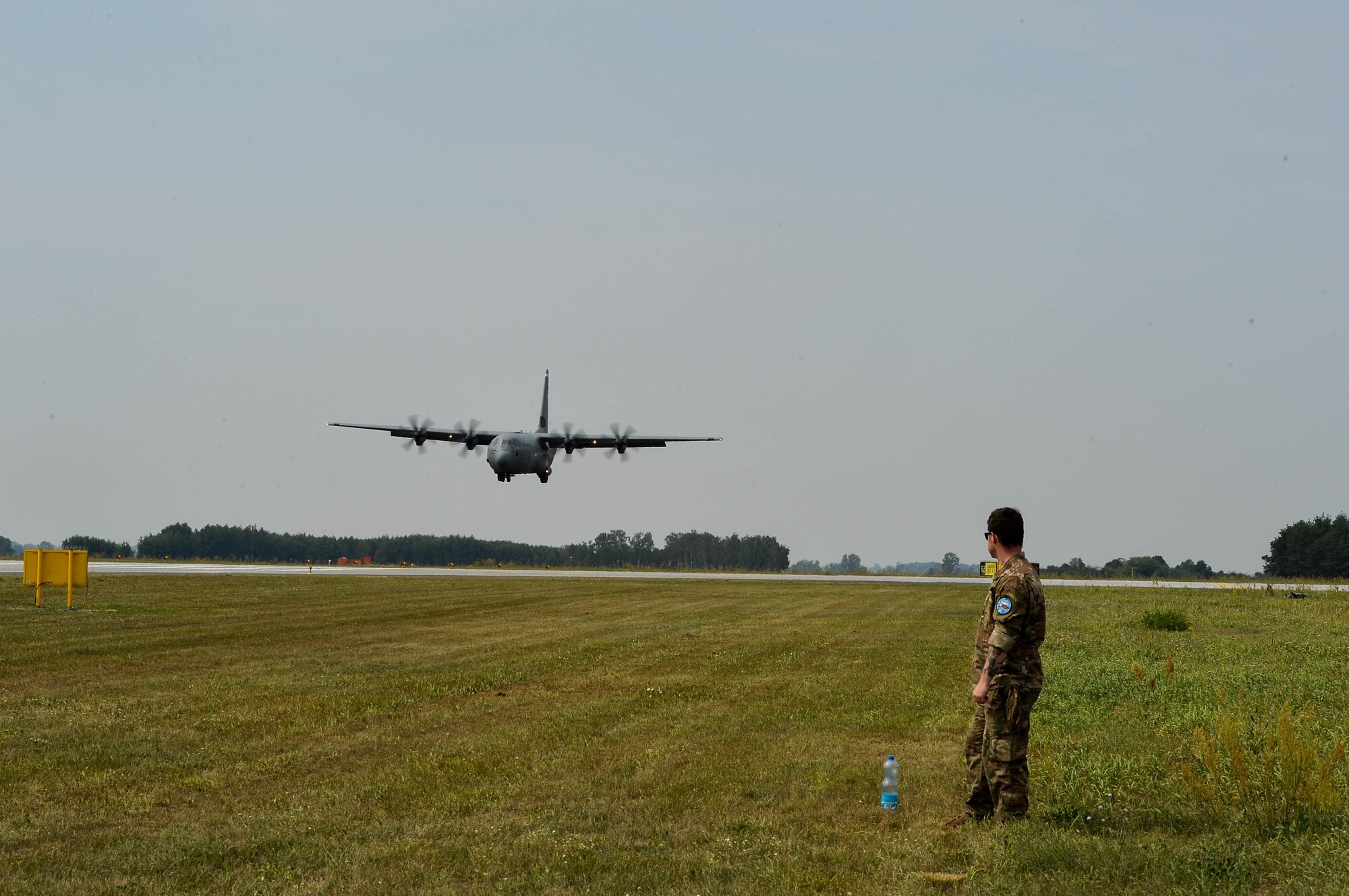 U.S. Air Force Tech. Sgt. Joshua Todd, 435th Contingency Response Group weather specialist, watches a Polish Air Force C-130E land on Powidz Air Base, Poland, Aug. 9, 2018. U.S. Airmen from Ramstein Air Base, Germany, arrived in Poland to conduct bilateral exercises with the Polish Air Force. (U.S. Air Force photo by Senior Airman Joshua Magbanua)