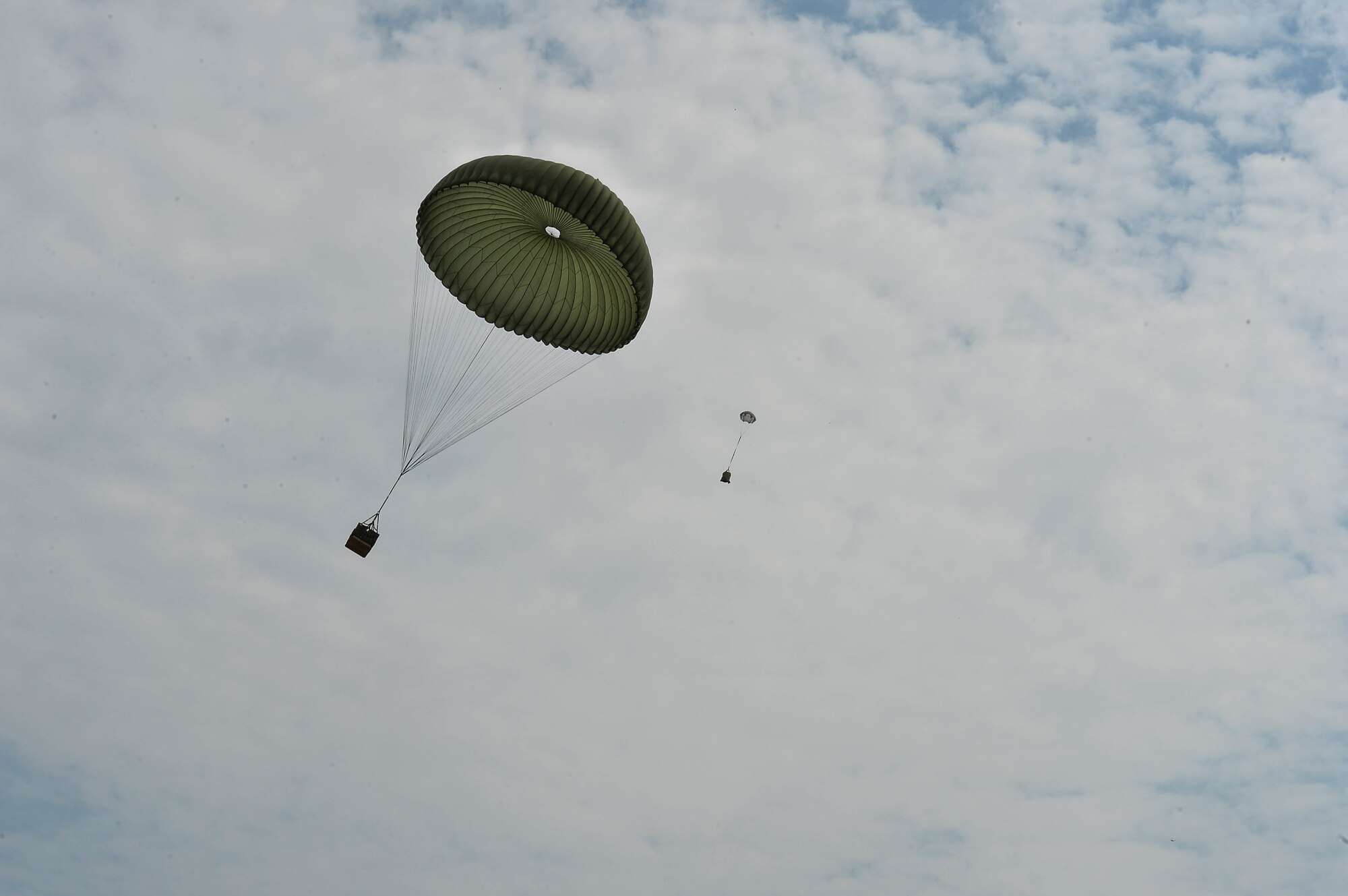 Airdropped container delivery packages descend upon Powidz Air Base, Poland, Aug. 9, 2018. U.S. and Polish aircraft dropped cargo and personnel  as part of a bilateral flight training exercise between the two nations’ air forces. (U.S. Air Force photo by Senior Airman Joshua Magbanua)