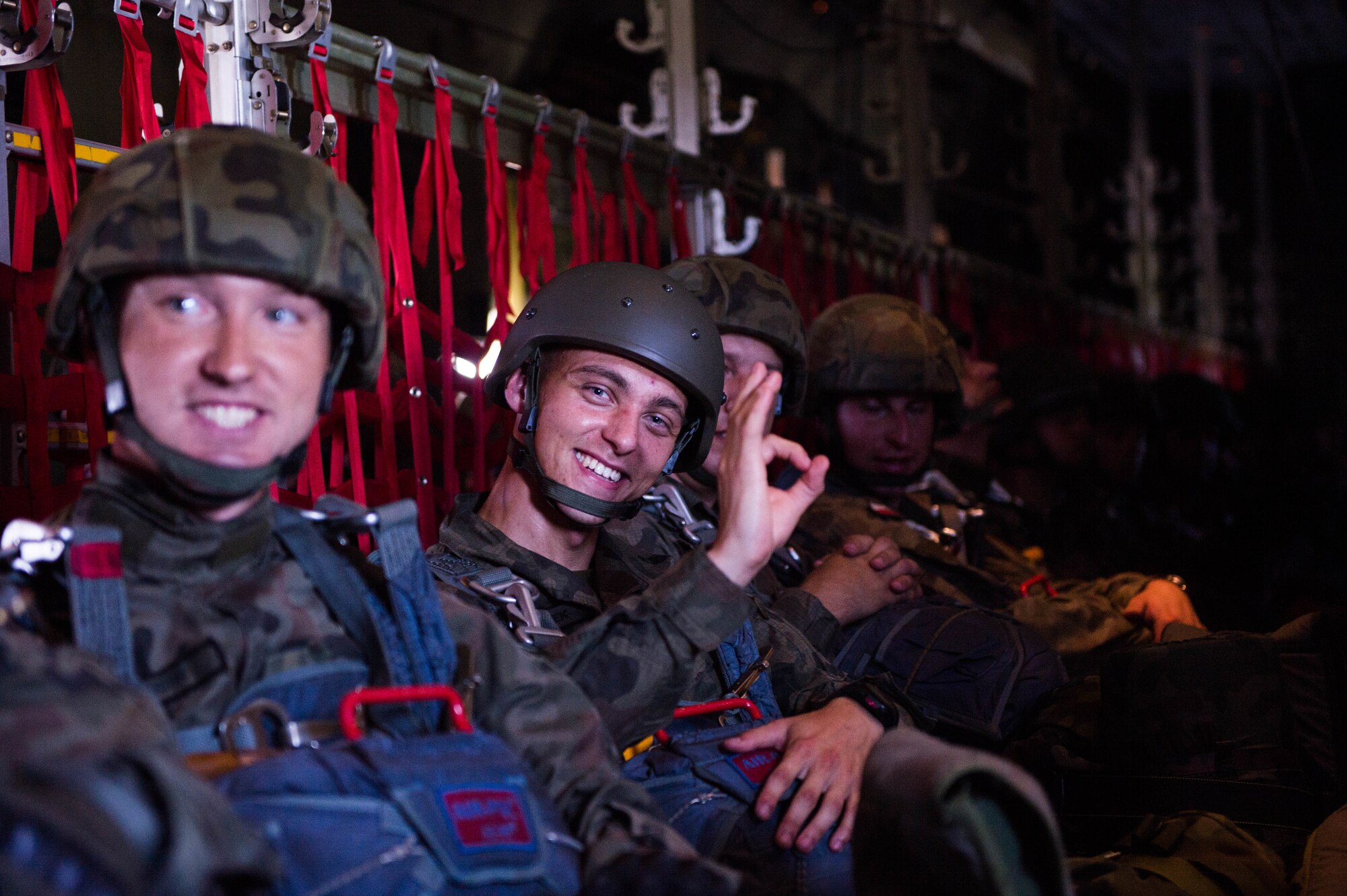 Polish paratroopers sit down after boarding a U.S. Air Force C-130J Super Hercules during Exercise Aviation Rotation 18-4 at Krakow, Poland, Aug. 7, 2018. The airdrop operations conducted during Aviation Rotation were static line jumps and High Altitude-Low Opening jumps. (U.S. Air Force photo by Senior Airman Joshua Magbanua)