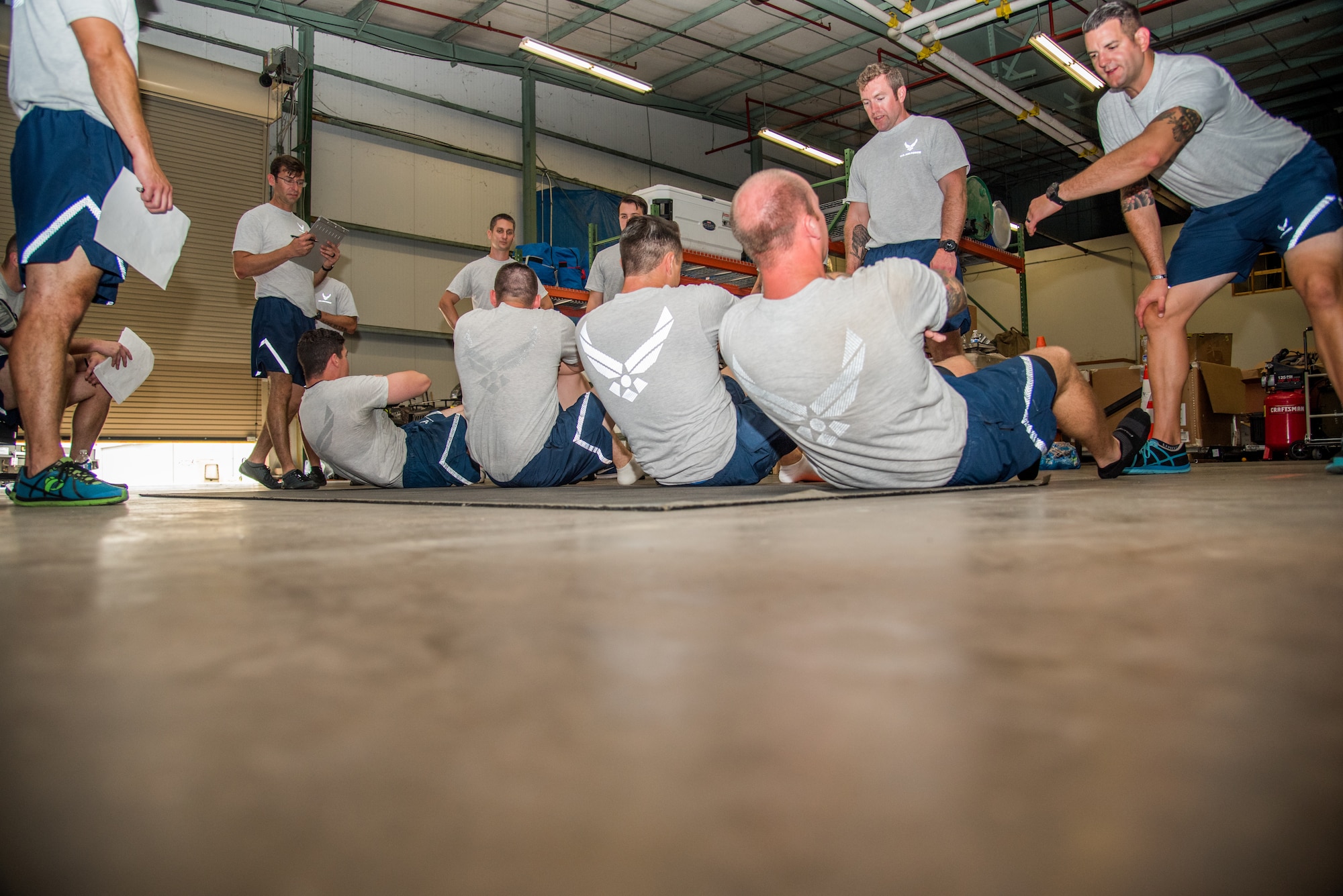 Explosive Ordnance Disposal Airmen perform the Extended Cross Knee Crunch Metronome component of the EOD Tier 2 Physical Fitness Test Prototype at Dover Air Force Base, Del., Aug. 8, 2018. The Tier 2 Physical Test prototype is designed to measure Airmen's ability to perform critical mission tasks for specific Air Force Specialty Codes.  (U.S. Air Force photo by Staff Sgt. Damien Taylor)