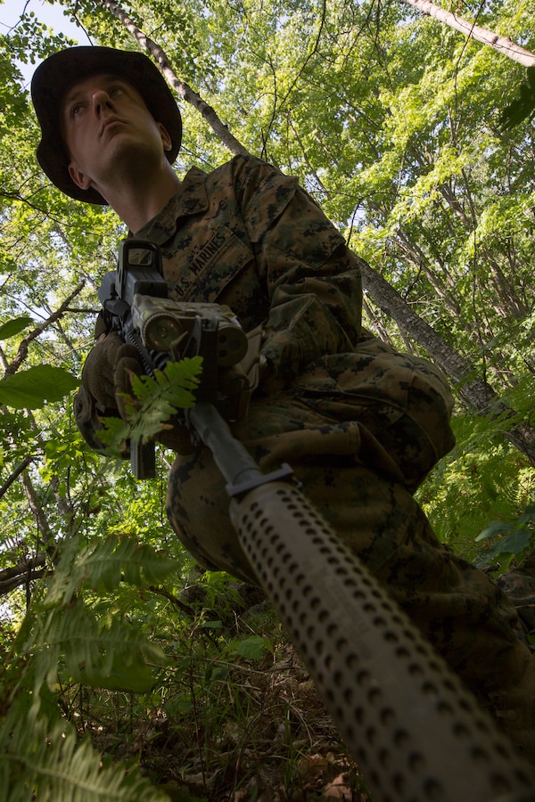 Sgt. Timothy Suba, a scout sniper with 3rd Battalion, 25th Marine Regiment, searches a road for enemy combatants before practicing crossing a danger zone with the rest of his squad during Exercise Northern Strike at Camp Grayling, Mich., Aug. 11, 2018. Exercise Northern Strike is a National Guard Bureau-sponsored training exercise that unites service members from multiple branches, states and coalition countries to conduct combined ground and air combat operations. (U.S. Marine Corps photo by Cpl. Niles Lee)