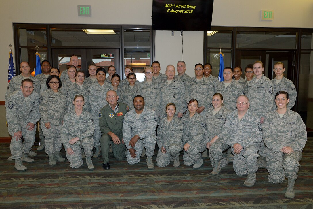 Reserve Citizen Airmen from the 302nd Airlift Wing pose for a group photo with retired Air Force Maj. Gen. Edward Mechenbier, after re-enlisting his daughter, Master Sgt. Kari Eubanks, 302nd Force Support Squadron, at Peterson Air Force Base, Colorado, Aug. 5, 2018.
