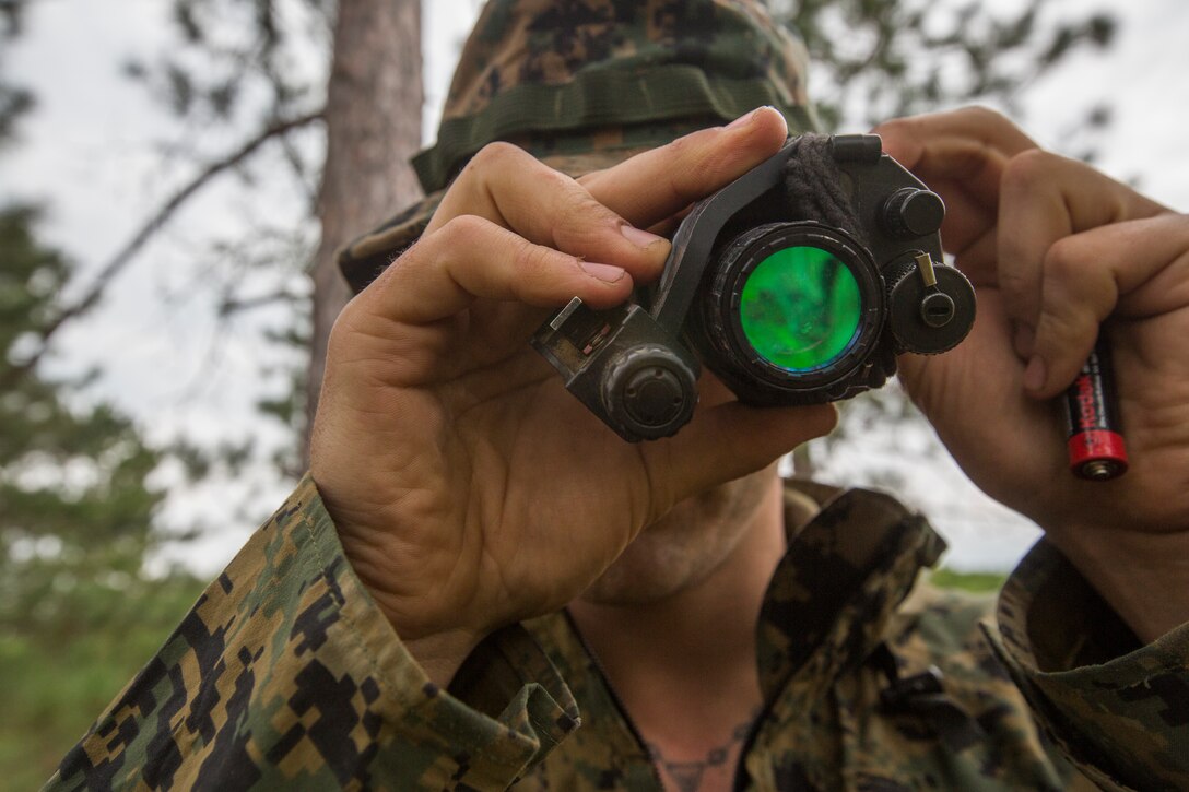 Sgt. David Bloxton, a scout sniper with 3rd Battalion, 25th Marine Regiment, inspects his night vision device before practicing patrolling drills during Exercise Northern Strike at Camp Grayling, Mich., Aug. 11, 2018. Camp Grayling, the largest National Guard center in the country covering 147,000 acres, offers many large artillery, mortar, tank ranges and maneuver courses. (U.S. Marine Corps photos by Cpl. Niles Lee)