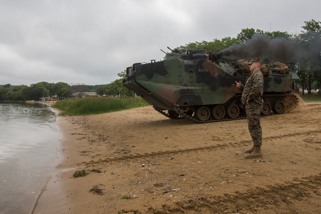 Sgt. Rick Asking, training non-commissioned officer in charge with Alpha Company, 4th Assault Amphibious Battalion, signals for an amphibious assault vehicle to enter a lake during Exercise Northern Strike at Camp Grayling, Mich., Aug. 8, 2018. Camp Grayling, the largest National Guard center in the country covering 147,000 acres, offers many large artillery, mortar, tank ranges and maneuver courses. (U.S. Marine Corps photos by Cpl. Niles Lee)