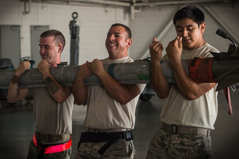 From left, U.S. Air Force Senior Airman James Bridges, 77th Aircraft Maintenance Unit (AMU) load crew team member, Staff Sgt. Samuel Ortiz 77th AMU load crew team lead, and Senior Airman Daniel Nunez, 77th AMU load crew team member, carry an AIM-9X sidewinder at Shaw Air Force Base, S.C., Aug. 9, 2018.