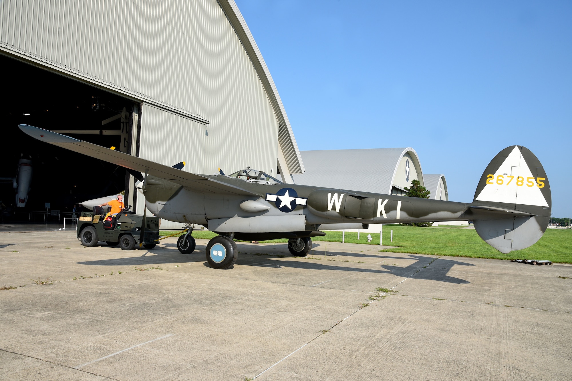 Roger Brigner, a museum restoration specialist at the National Museum of the U.S. Air Force, moves the Lockheed P-38L Lightning toward the WWII Gallery on Aug. 13, 2018. Several WWII era aircraft were temporarily placed throughout the museum to provide adequate space for the Memphis Belle exhibit opening events. (U.S. Air Force photo by Ken LaRock)