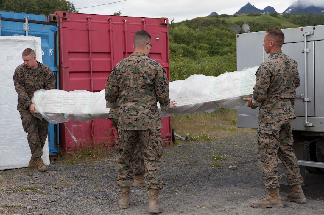 Marines with Marine Wing Support Squadron 471, 4th Marine Aircraft Wing unload a shipment of construction equipment during Innovative Readiness Training, Old Harbor, Alaska, Aug. 5, 2018. This year marks the completion of the 2,000-foot extension of Old Harbor’s runway. (U.S. Marine Corps photo by Lance Cpl. Tessa D. Watts)