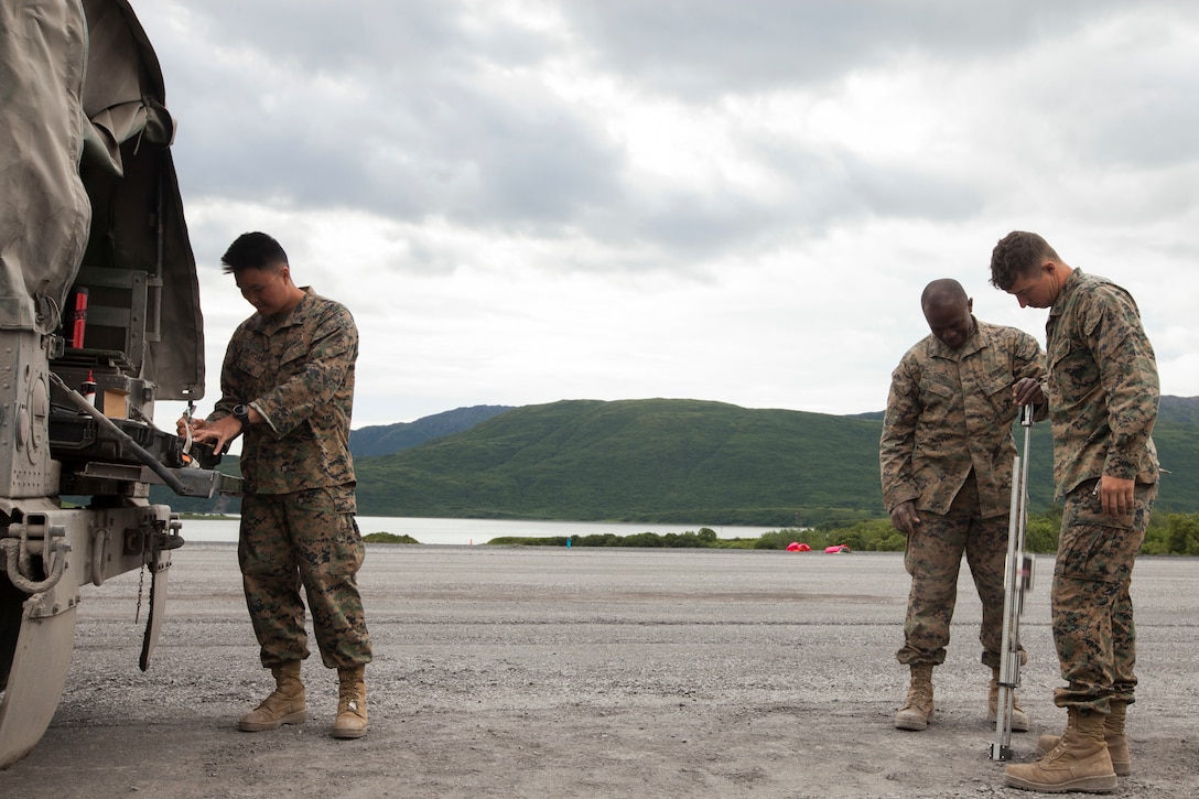 Cpl. Miky Vilaysane, a refueler with Marine Wing Support Squadron 471, 4th Marine Aircraft Wing, Cpl. Aziz Sumo, a mechanic with MWSS-471, and Cpl Steve Anderson, a refueler with MWSS-471, operate the dynamic cone penetrometer to test the density of the 2,000-foot runway extension during Innovative Readiness Training Old Harbor, Aug. 6, 2018. The IRT program supports troops’ readiness to fight through training, while serving American communities. (U.S. Marine Corps photo by Lance Cpl. Tessa D. Watts)