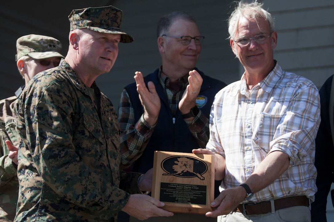 The Mayor of Old Harbor, Rick Berns presents a plaque to Brig. Gen. Bradley S. James, commanding general of 4th Marine Aircraft Wing, at the Old Harbor School Aug. 7, 2018. The plaque was awarded to Marine Forces Reserve to thank them for their commitment and dedication while constructing the extended runway as a part of Innovative Readiness Training Old Harbor, Alaska. (U.S. Marine Corps photo by Lance Cpl. Tessa D. Watts)