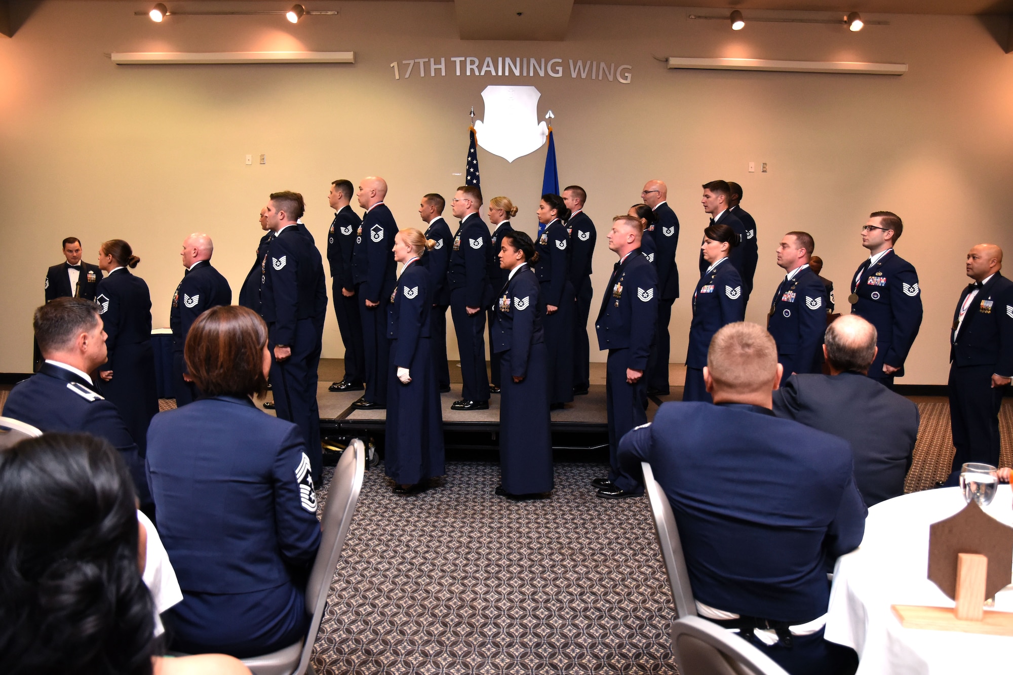 Goodfellow senior noncommissioned officer inductees listen and respond to the senior NCO charge read by Chief Master Sgt. Lavor Kirkpatrick, 17th Training Wing command chief, at the Event Center on Goodfellow Air Force Base, Texas, Aug. 10, 2018. The charge reminds the inductees of the responsibilities that they are taking on in this new position of leadership. (U.S. Air Force photo by Airman 1st Class Seraiah Hines/Released)