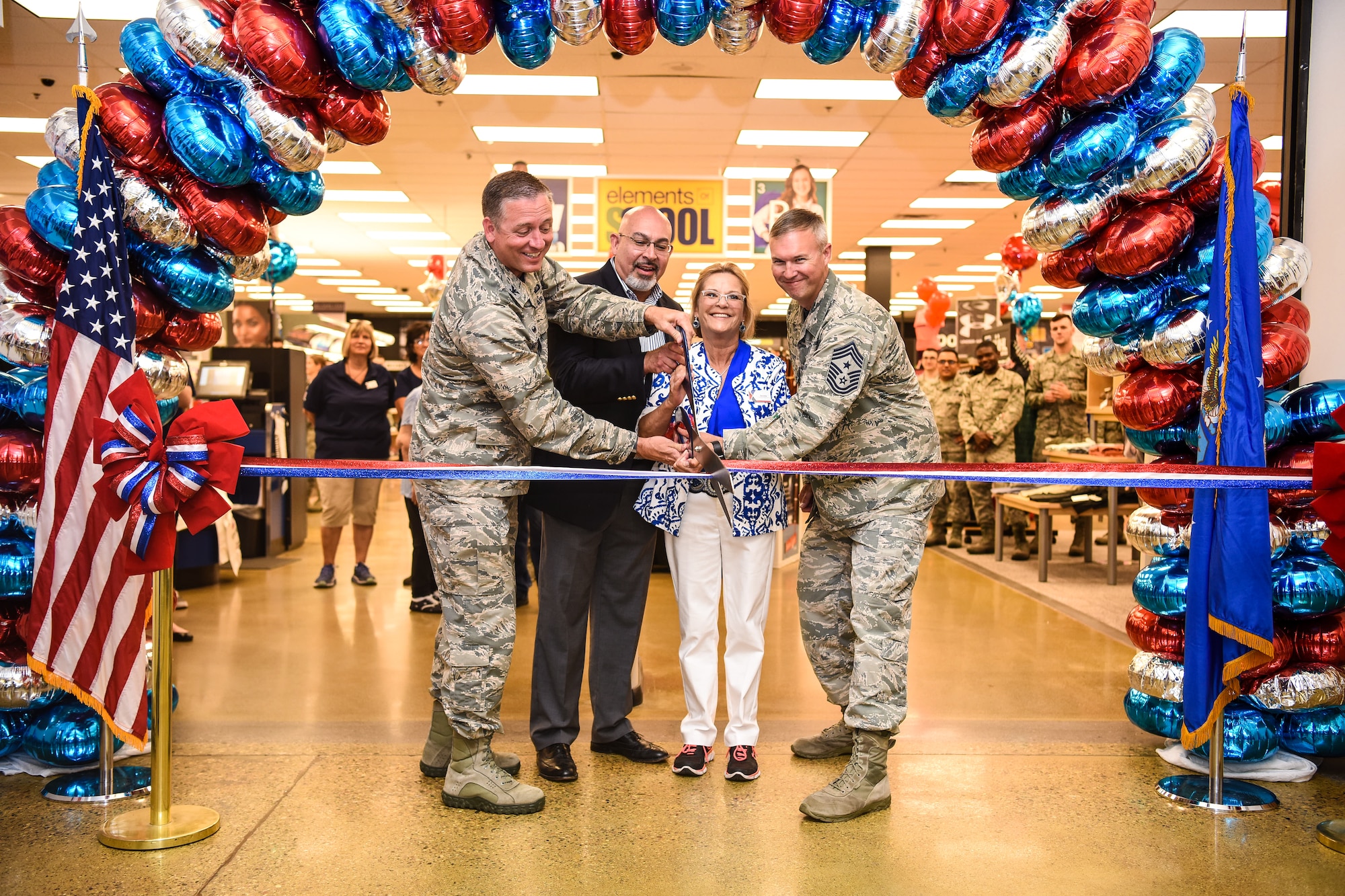 319th Air Base Wing Commander Col. Benjamin Spencer cuts the ribbon on the renovated Army & Air Force Exchange Service exchange during a grand reopening celebration August 10th alongside AAFES Central Regional Vice President Larry Salgado, Exchange General Manager Annette Montgomery, and 319th Air Base Wing Command Chief Master Sergeant Brian Thomas. Since 1895 AAFES has supported America's military men and women and completed store renovations within six months at Grand Forks Air Force Base, North Dakota.