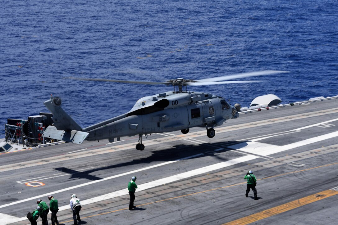 An MH-60R Seahawk helicopter lands on the flight deck.