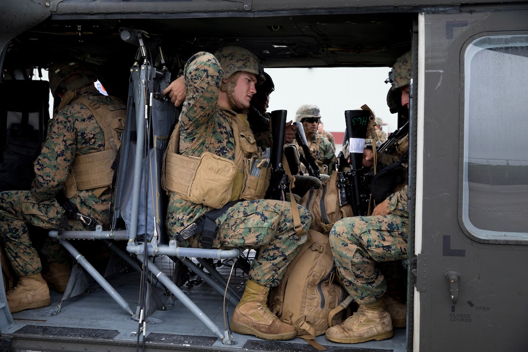 Marines board an Army UH-60 Black Hawk helicopter.