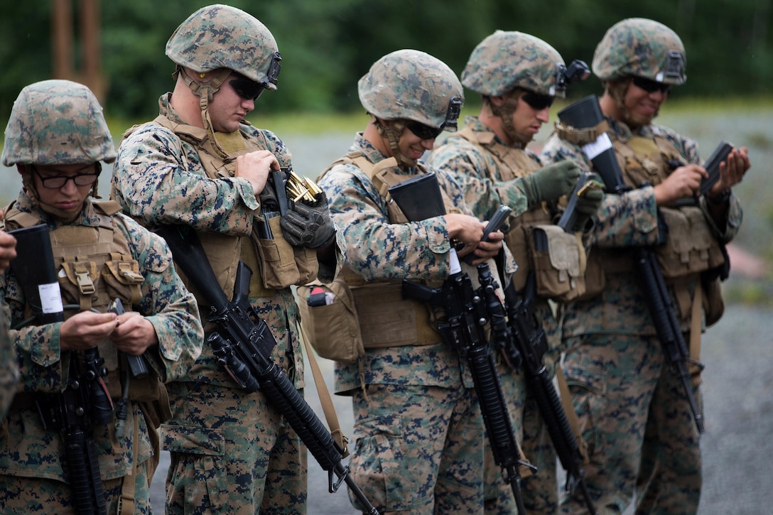 Marines prepare rifle magazines.
