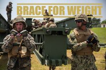 Lance Cpl. Michael Braceland, left, and Seaman Ignacio Munguia, right, lift up part of a medium girder bridge during a multi-level bridging operation Aug. 9, 2018 at Camp Hansen, Okinawa, Japan.