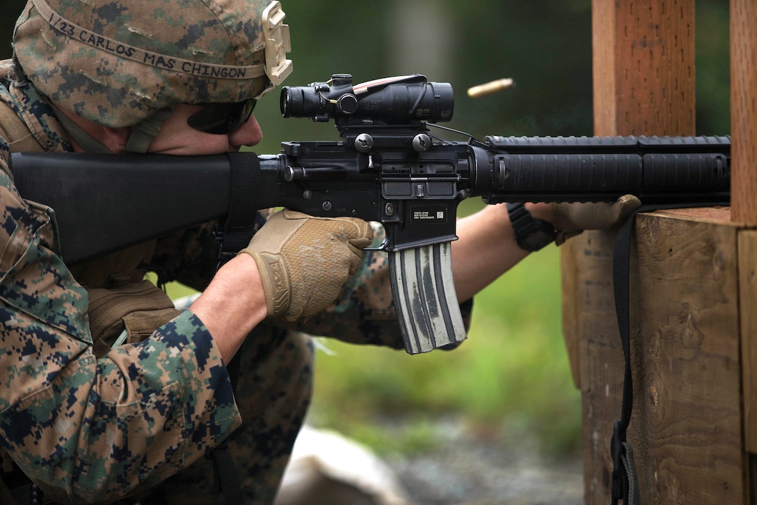 A Marine fires his rifle from the kneeling position.