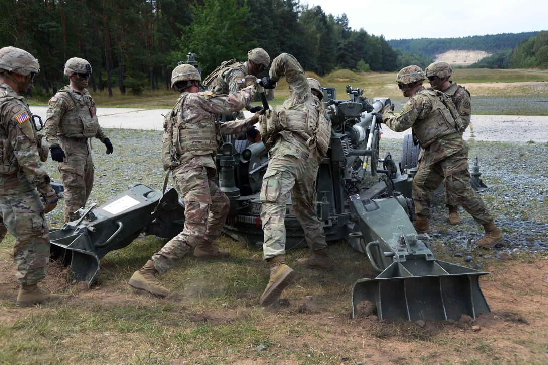 Soldiers load a round into an M777A2 howitzer during a live-fire exercise.