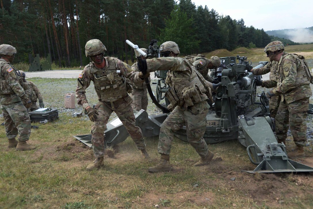 Soldiers clear the barrel after firing an M777A2 howitzer during a live-fire exercise.