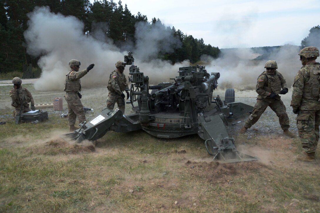 A soldier prepares to pull the lanyard before firing an M777A2 howitzer.