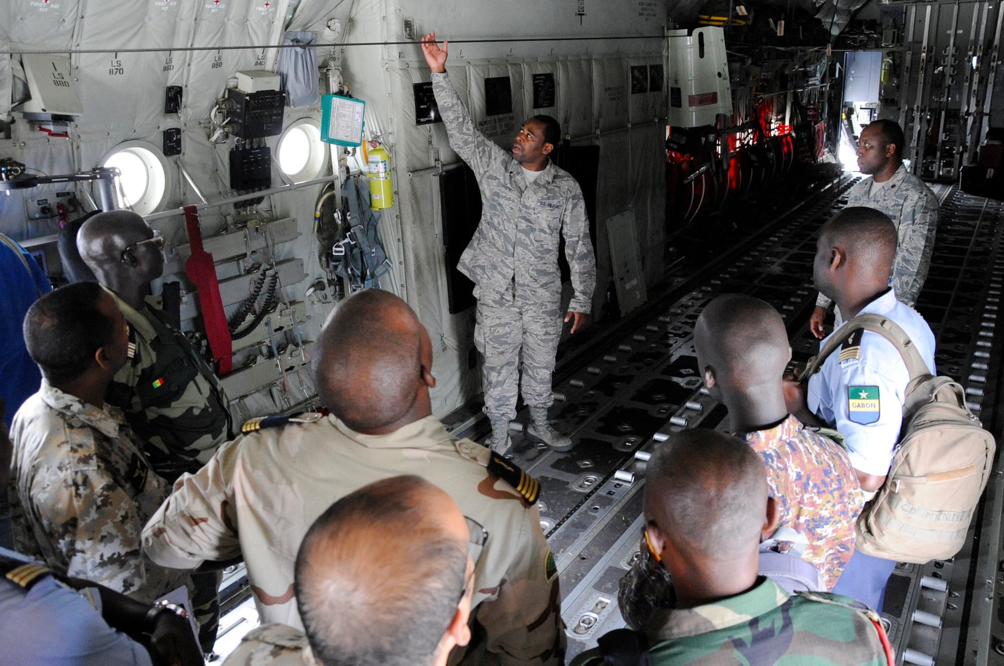 U.S. Air Force Staff Sgt. Kyle Chestnut, a Flying Crew Chief assigned to 86th Air Maintenance Squadron, shows the inside of a C-130 aircraft to participants of African Partnership Flight, hosted by U.S. Air Forces Africa and co-hosted by Mauritania and Senegal at Ramstein Air Base, Germany, Aug. 7, 2018. The APF program is Air Forces in Africa's premier security cooperation program with African partner nations to improve professional military aviation knowledge and skills. (U.S. Army photo by Spc. Craig Jensen)