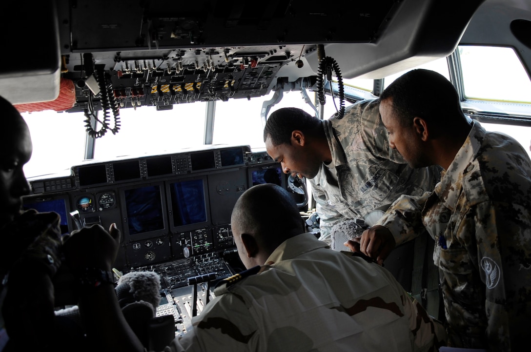 U.S. Air Force Staff Sgt. Kyle Chestnut, a Flying Crew Chief assigned to 86th Air Maintenance Squadron, shows a C-130 aircraft cockpit to participants of African Partnership Flight, hosted by U.S. Air Forces Africa and co-hosted by Mauritania and Senegal at Ramstein Air Base, Germany, Aug. 7, 2018. The APF program is Air Forces in Africa's premier security cooperation program with African partner nations to improve professional military aviation knowledge and skills. (U.S. Army photo by Spc. Craig Jensen)