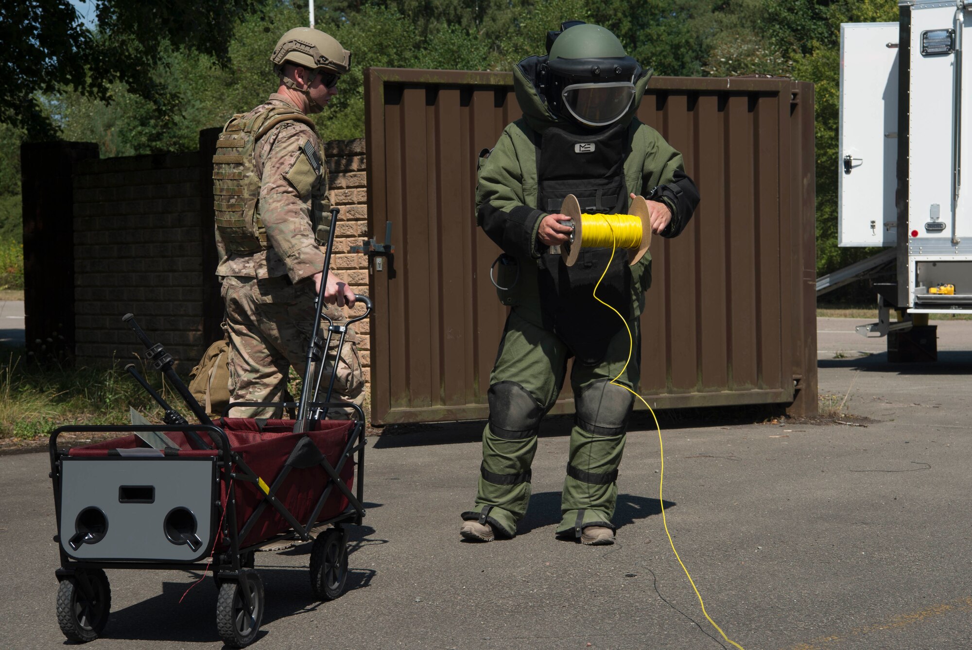 U.S. Air Force Staff Sgt. Jameson Baehler, right, 786th Civil Engineer Squadron Explosive Ordinance Disposal technician, lays down shock tube to trigger an explosive, while Staff Sgt. Geoffrey Hagle, 786th CES EOD technician, transports explosive disarmament equipment during training on Ramstein Air Base, Germany, Aug. 2, 2018. EOD Airmen train continually to prepare for the days when they are saving lives, and to stay ahead of adversaries. (U.S. Air Force photo by Senior Airman Elizabeth Baker)