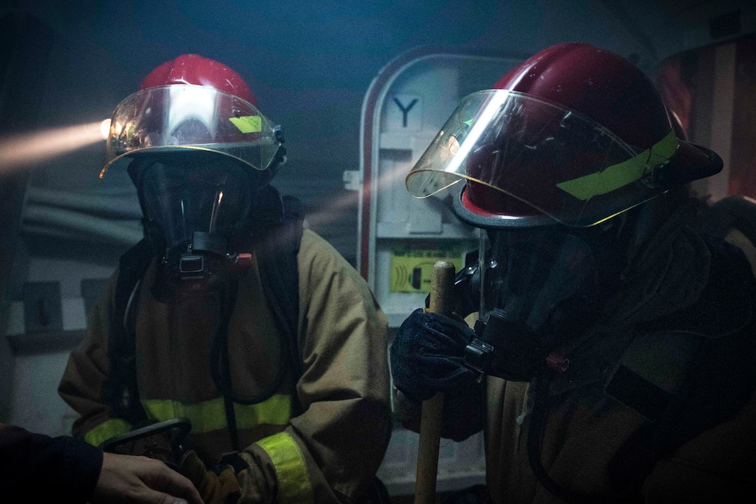 Sailors receive firefighting instructions on how to fight a simulated fire.