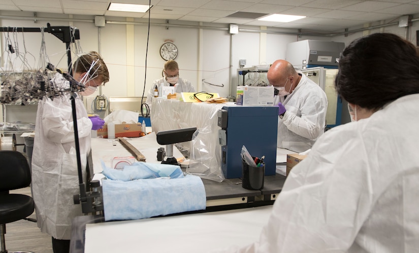 A group of latent print examiners assigned to the Forensic Exploitation Laboratory – Central Command, work side-by-side to extract samples from captured enemy material at Camp Arifjan, Kuwait, August 9, 2018. The FXL-C provides vital information to combatant commanders in the CENTCOM area of responsibility which helps them stay ahead of the fight.