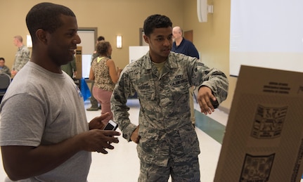 Senior Airman Federico Rodrigo, 437th Operations Support Squadron mission airlift specialist, right, and Staff Sgt. William Washington, 628th Contracting Squadron contract specialist, left, look at one of the displays during Diversity Day Aug. 10, 2018, at the base Chapel Annex.