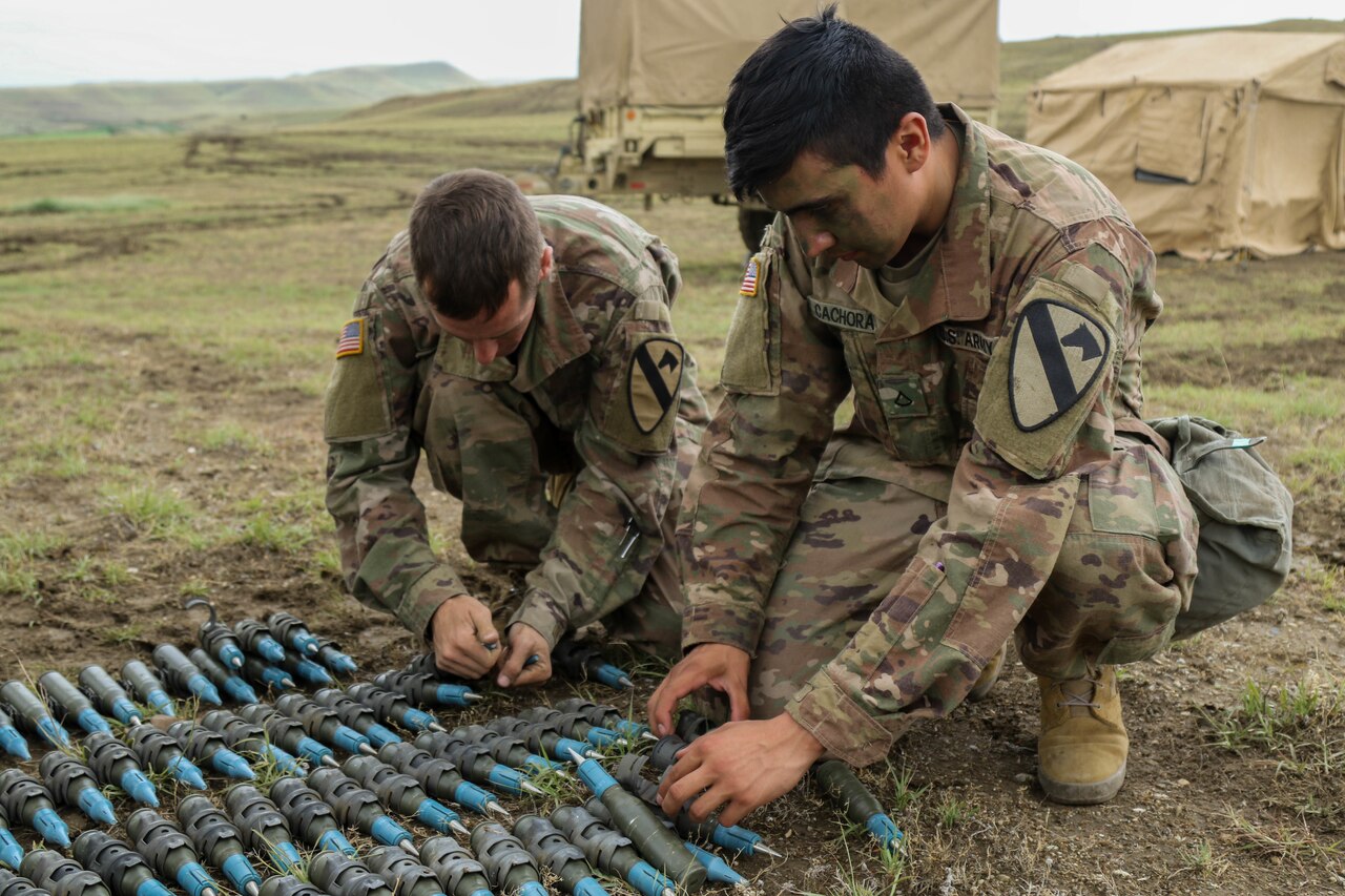 Soldiers prepare artillery rounds.