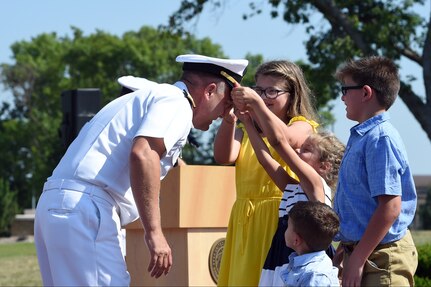 U.S. Navy Rear Adm. John Spencer's daughters don his new combination cover with golden oak leaf during his promotion ceremony on the missile deck at U.S. Strategic Command (USSTRATCOM) headquarters on Offutt Air Force Base, Neb., Aug. 9, 2018. Spencer is the executive assistant to U.S. Air Force Gen. John Hyten, commander of USSTRATCOM. His next assignment will be the director of Nuclear Support Directorate, Defense Threat Reduction Agency at Ft. Belvoir, Va.  USSTRATCOM has global responsibilities assigned through the Unified Command Plan that include strategic deterrence, nuclear operations, space operations, joint electromagnetic spectrum operations, global strike, missile defense, and analysis and targeting. (U.S. Navy photo by Mass Communication Specialist 1st Class Julie R. Matyascik/Released)