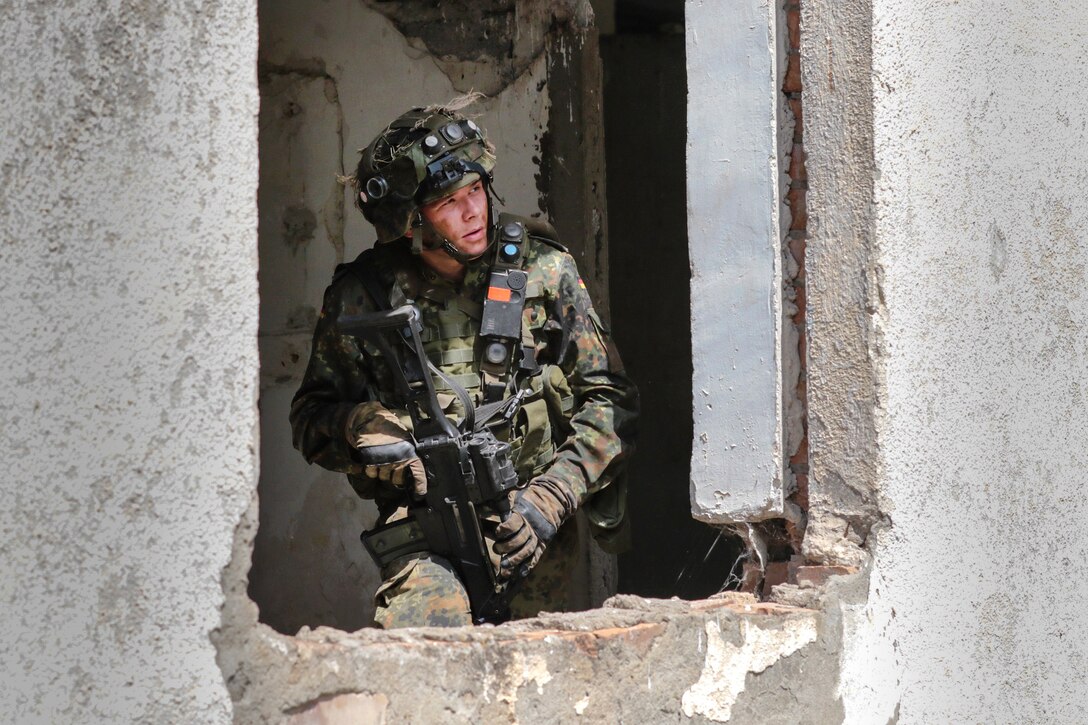 A German soldier scans his sector while providing security from an abandoned building during an urban operations exercise as part of Noble Partner 18 at the Vaziani Training Area, Georgia.