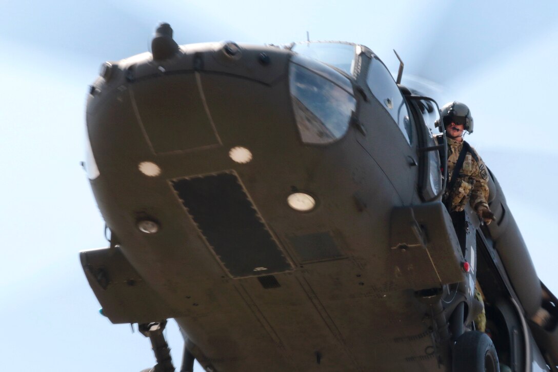 An Army crew chief looks out of the machine-gunner’s door of an UH-60 Black Hawk helicopter during an air insertion exercise as part of Noble Partner 18 at the Vaziani Training Area, Georgia.