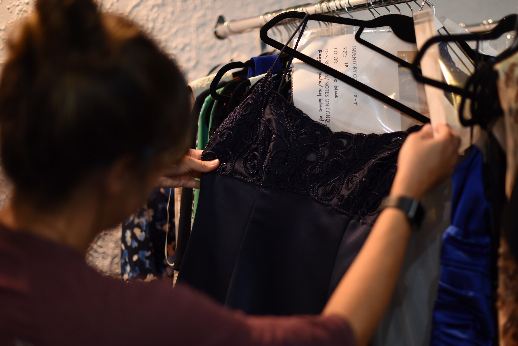 A patron of Operation Ball Gown, a free gown loan service, picks out dresses at Kirtland Air Force Base, N.M., August 13, 2018. The service provides Department of Defense ID card holders dresses for both military and non military related functions. (U.S. Air Force photo by Senior Airman Eli Chevalier)