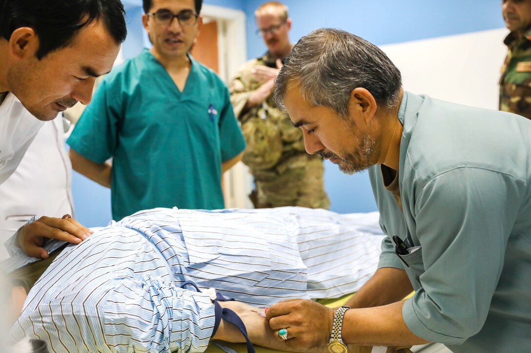 Afghan radiology technicians prepare a patient for a body scan.