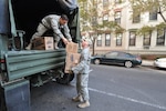 Army Sgt. Joseph Barbado, right, a New Jersey National Guard Soldier, unloads heater meals from a five-ton truck at a distribution point in Hoboken, Nov. 5.