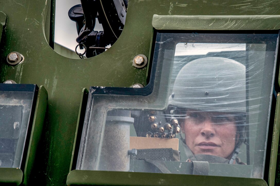 An airman looks out the window of a humvee.