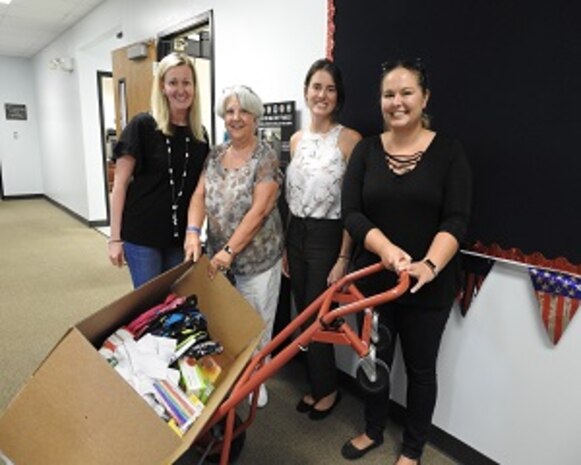 PANAMA CITY, Florida - Naval Surface Warfare Center Panama City Division (NSWC PCD) Test and Evaluation Prototype Fabrication employees pose for a photo with Rebecca Christopher (left), vice principal at Breakfast Point Academy. School administrators stated they were thankful to receive the items because they had not received donations for the school year. Pictured from left to right: Nicole Waters, Dr. Ben Schlorholtz, and Paula Oliver. Pictured from left to right: Rebecca Christopher, Paula Oliver, Halie Cameron, and Nicole Waters. U.S. Navy photo by Susan H. Lawson