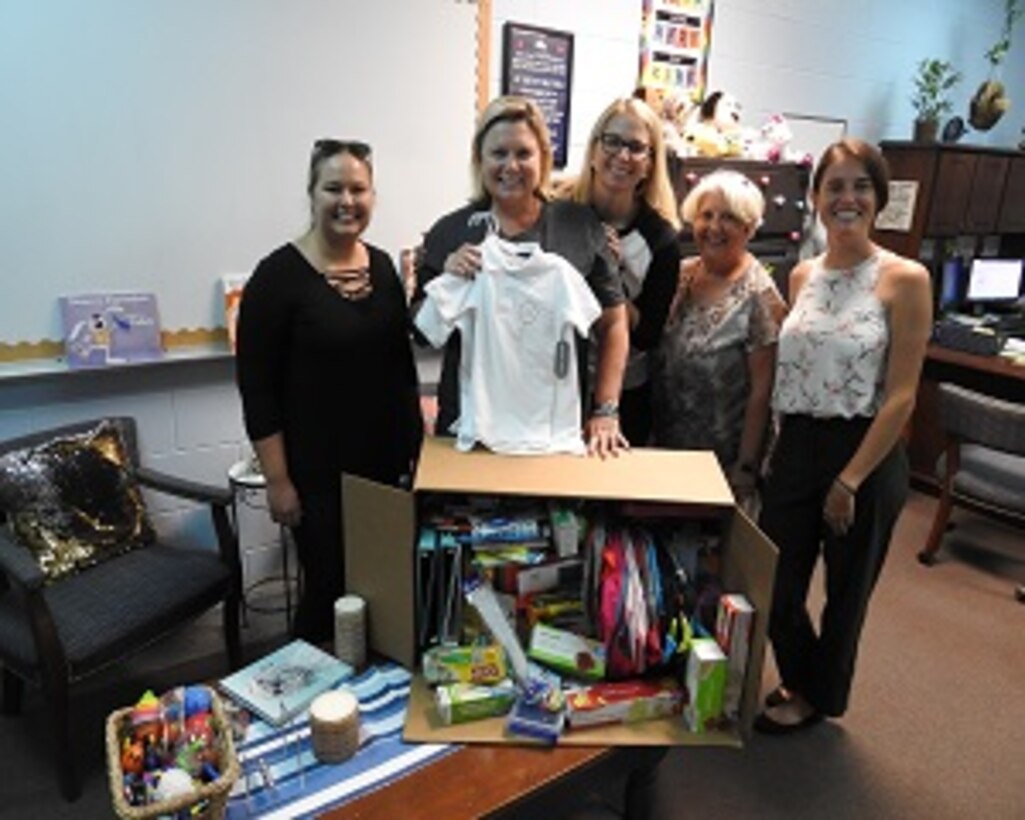 PANAMA CITY, Florida - Deniece Moss (center), principal at West Bay Elementary School poses with employees of Naval Surface Warfare Center Panama City Division’s (NSWC PCD) Test and Evaluation Prototype Fabrication Division. The group collected needed school supplies for Bay District School students in Panama City Beach, Florida August 13, 2018. Pictured from left to right: Nicole Waters, Deniece Moss, Michelle Armistead, Paula Oliver, and Halie Cameron. U.S. Navy photo by Susan H. Lawson