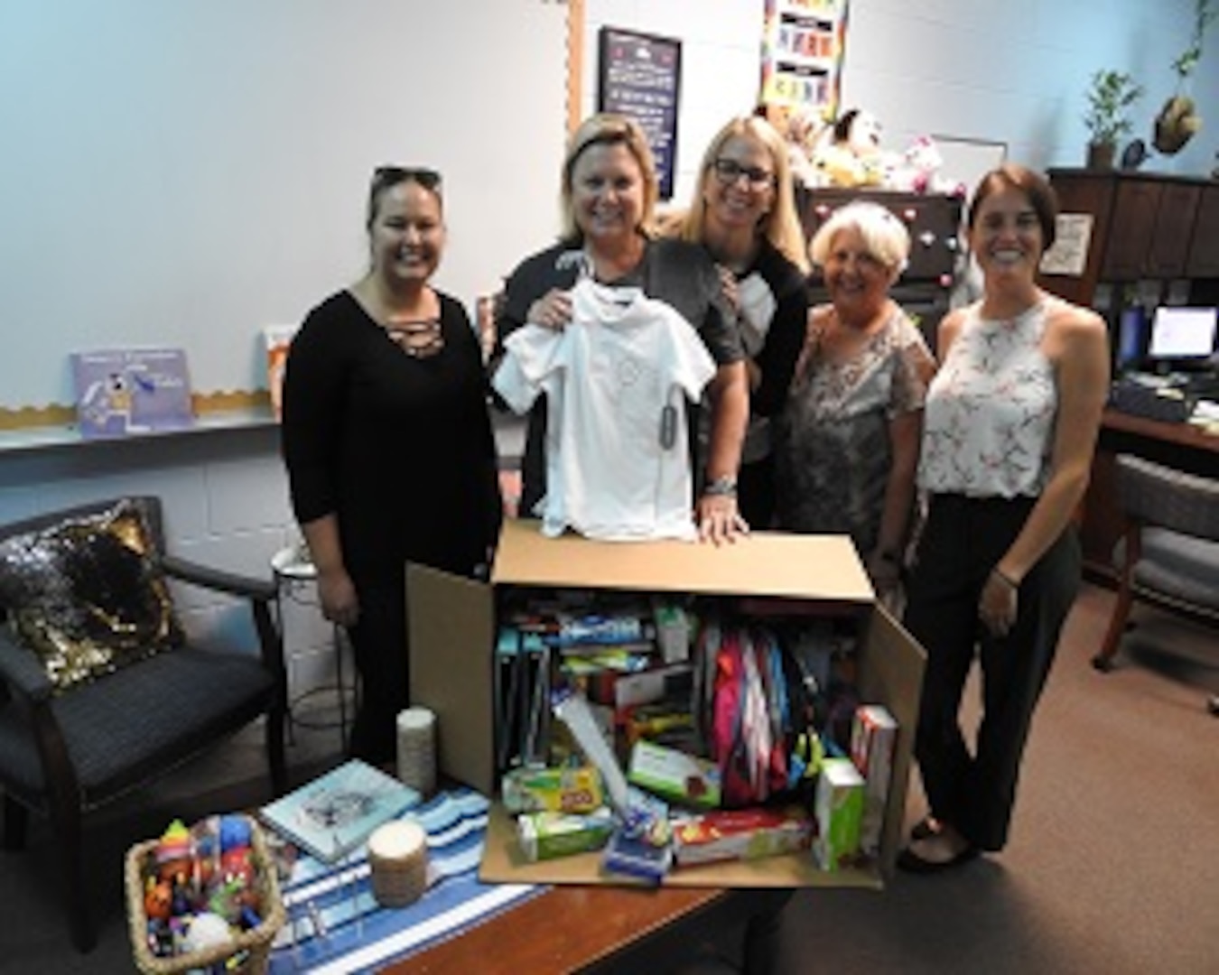 PANAMA CITY, Florida - Deniece Moss (center), principal at West Bay Elementary School poses with employees of Naval Surface Warfare Center Panama City Division’s (NSWC PCD) Test and Evaluation Prototype Fabrication Division. The group collected needed school supplies for Bay District School students in Panama City Beach, Florida August 13, 2018. Pictured from left to right: Nicole Waters, Deniece Moss, Michelle Armistead, Paula Oliver, and Halie Cameron. U.S. Navy photo by Susan H. Lawson