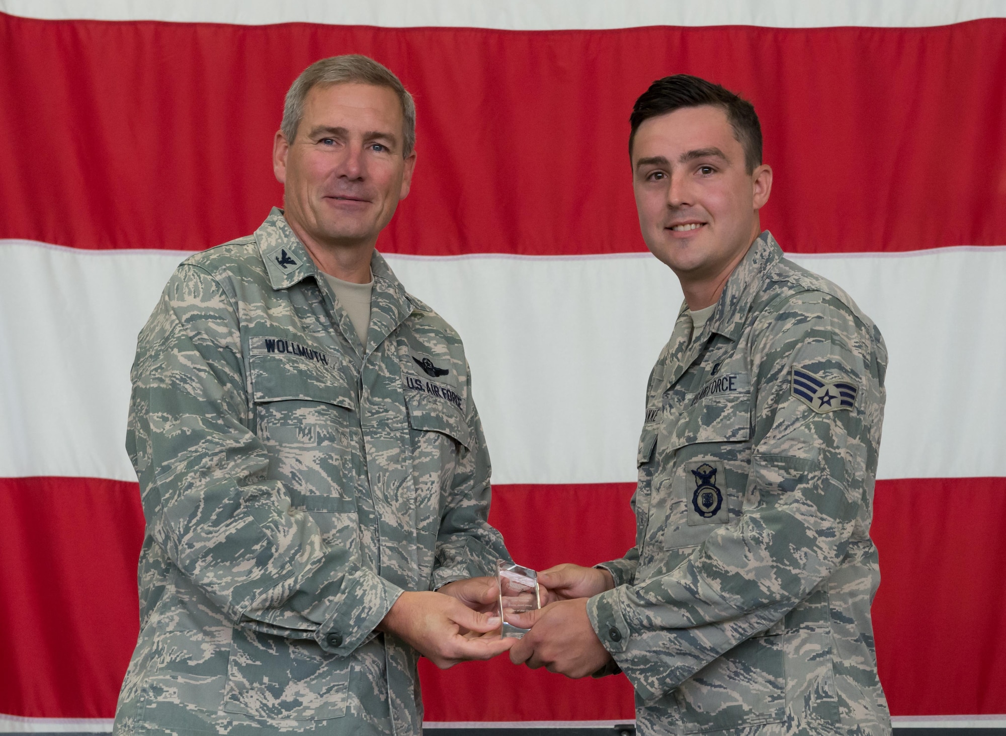 Senior Airman Joel Bakke, 934th Security Forces Squadron, receives the Airman of the Quarter award from Col. Tim Wollmuth, 934th Airlift Wing vice commander, Aug. 5. (Air Force Photo/Tech. Sgt. Amber E.N. Jacobs)
