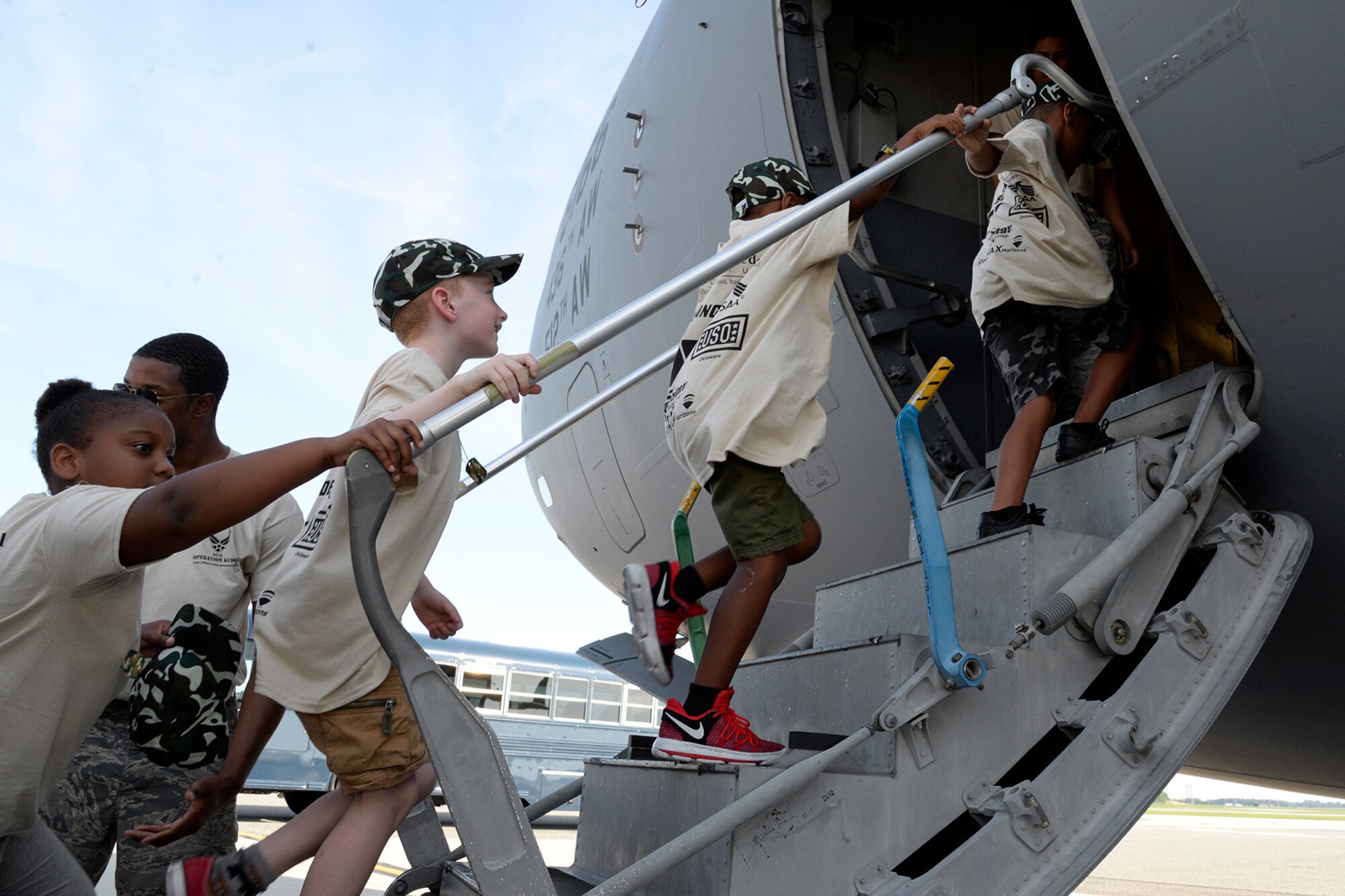 Children enter a static C-17 Globemaster III during a Kids/Teachers Understanding Deployment Operations event Aug. 9, 2018, at Dover Air Force Base, Del. Children and teachers got to see how mobility Airmen deploy around the world and what equipment is used to get them there. (U.S. Air Force photo by Tech. Sgt. Matt Davis)