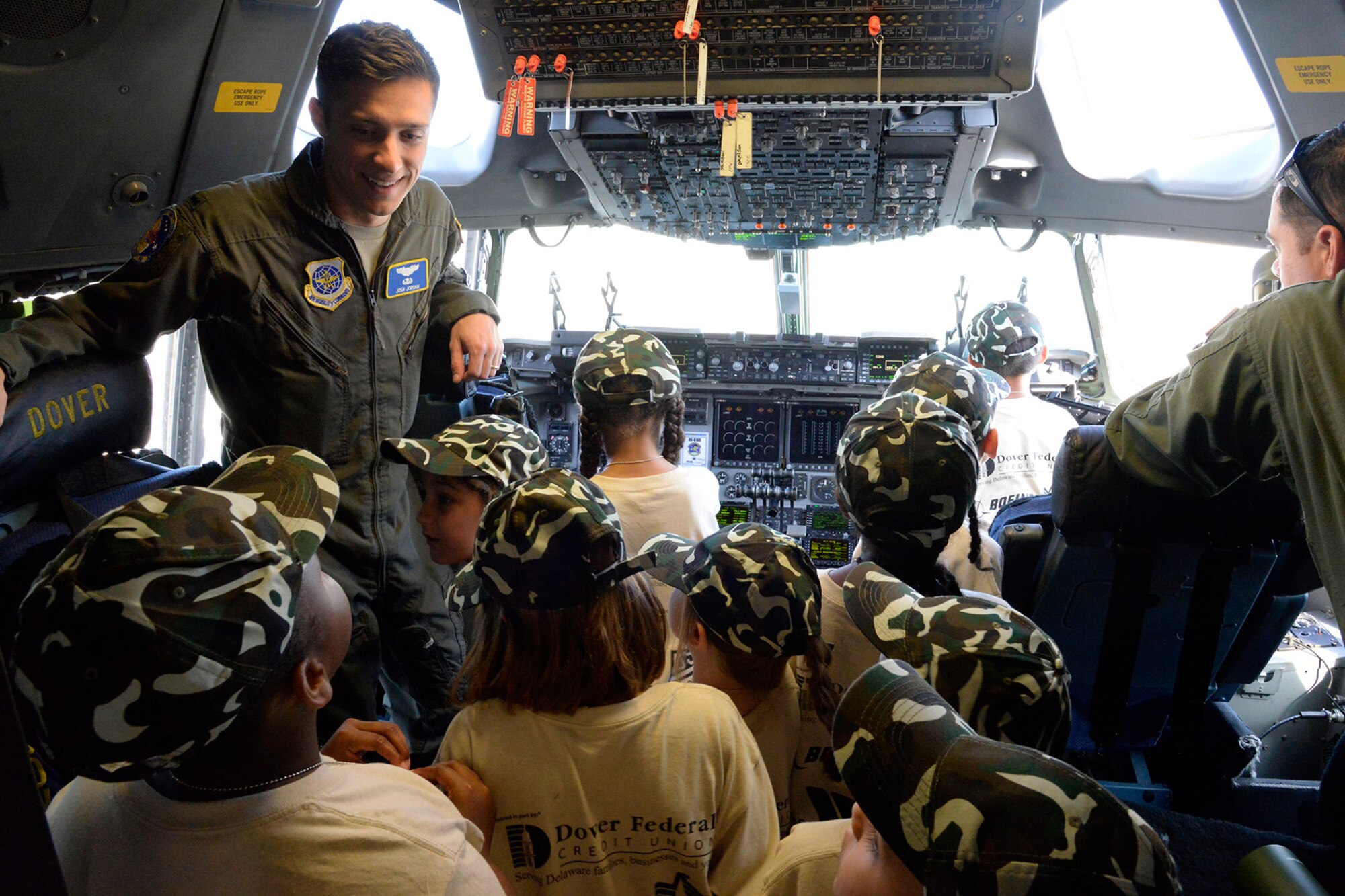 First Lt. Josh Jordan, 3rd Airlift Squadron pilot, shows children the cockpit of a static C-17 Globemaster III during a Kids/Teachers Understanding Deployment Operations event Aug. 9, 2018, at Dover Air Force Base, Del. Children and teachers attending the event received a behind-the-scenes view of Team Dover’s mobility aircraft. (U.S. Air Force photo by Tech. Sgt. Matt Davis)