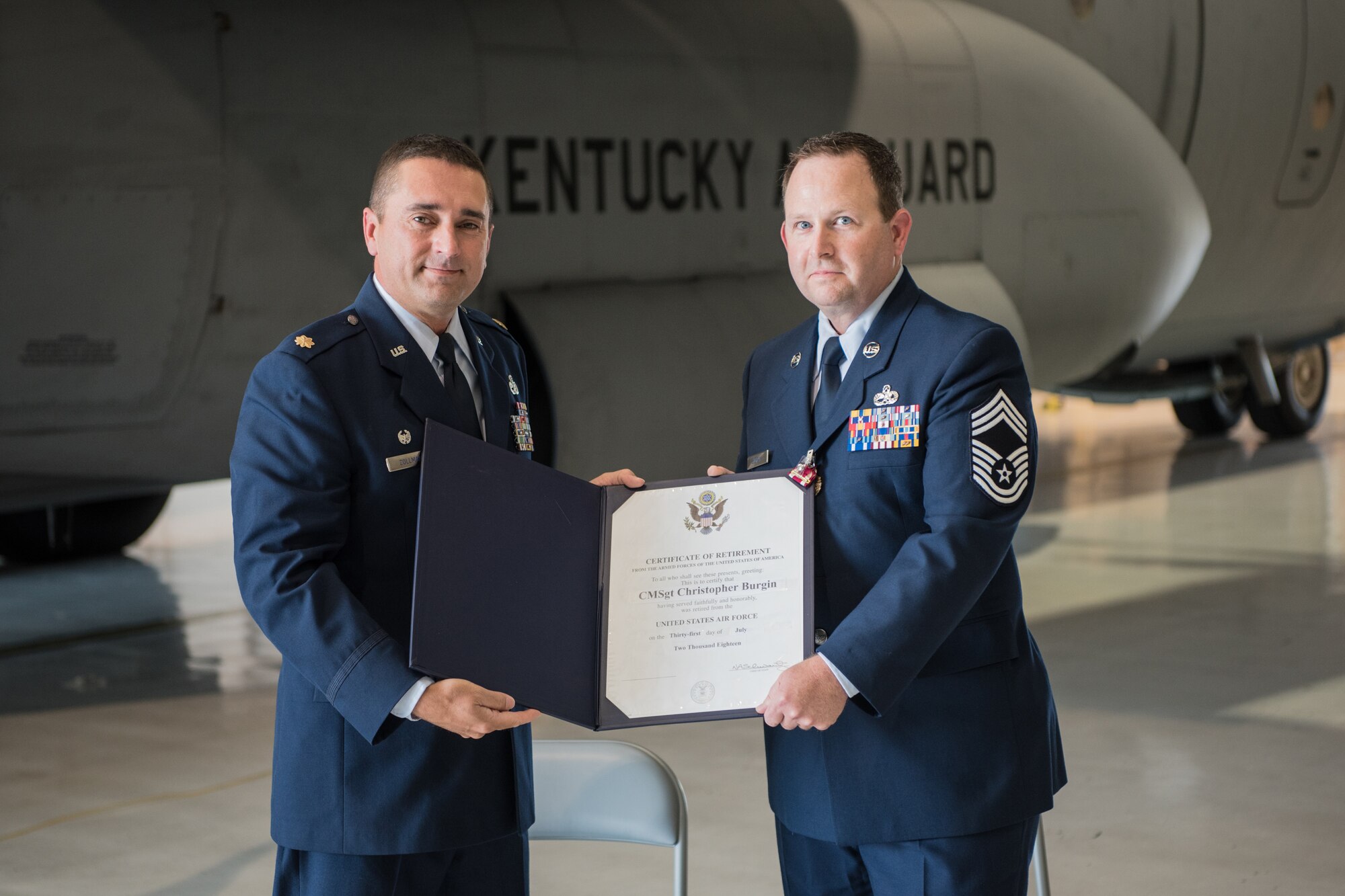 Maj. Jerry Zollman (left), commander of the 123rd Maintenance Squadron, presents the certificate of retirement to Chief Master Sgt. Chris Burgin, superintendent of the 123rd Maintenance Group, during Burgin's retirement ceremony at the Kentucky Air National Guard base in Louisville, Ky., on July 14, 2018. Burgin was the first chief master sergeant selected to fill the newly created superintendent position for the 123rd Maintenance Group. (U.S. Air National Guard photo by Master Sgt. Phil Speck)