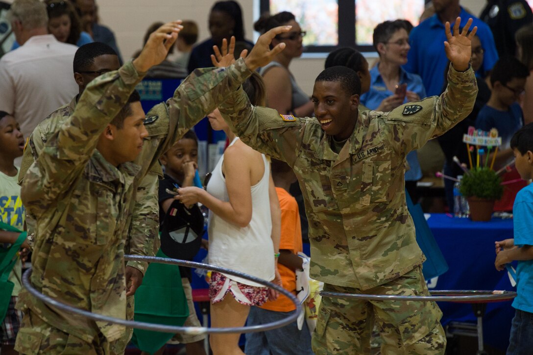 Soldiers hula-hoop with children during the Army Community Service block party at Gen. Stanford Elementary School on Joint Base Langley-Eustis, Virginia, Aug. 9, 2018.